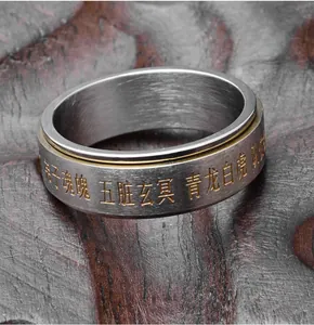 Vue macro de la bague rotative en acier inoxydable avec mantras taoïstes gravés et anneau doré