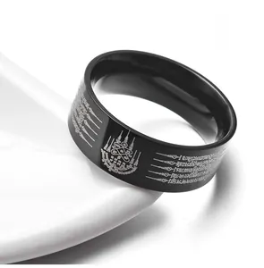 Close-up of black stainless steel ring featuring white Thai religious scripture motifs