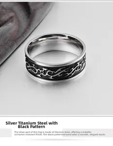 Macro detail of wide titanium steel ring with black enamel dragon pattern and polished finish