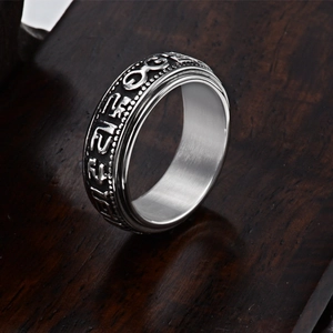 Macro shot of silver titanium steel rotating ring with embossed Sanskrit mantra carving