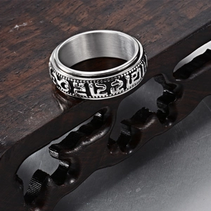 Detailed macro view of rotatable stainless steel ring with relief Buddhist symbols