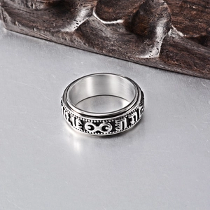 Macro view showing the silver spinner ring with engraved Om Mani Padme Hum mantra