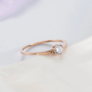 Macro shot of rose gold ring featuring a classic six-prong setting with a round zircon stone