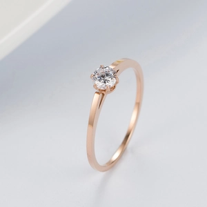 Detail of rose gold ring with a six-prong solitaire round-cut zircon setting