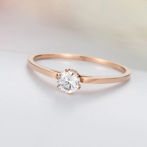 Macro shot of rose gold ring featuring a four-prong set sparkling round zircon stone