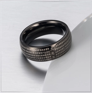 Macro shot of black titanium steel ring featuring laser-engraved Buddhist scriptures