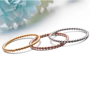 Three minimalist spiral twist stackable rings in gold, silver, and rose gold finishes