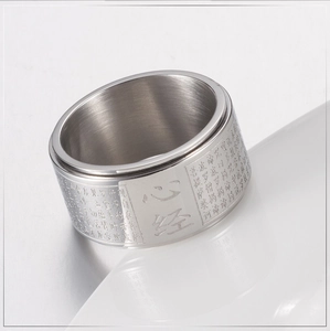 Detailed view of rotating wide Buddhist Heart Sutra ring in silver stainless steel