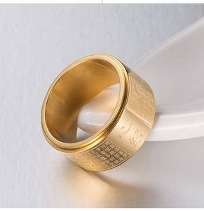 Macro shot of gold stainless steel spinning ring with engraved Buddhist Heart Sutra