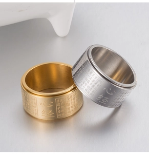Detailed close-up of gold and silver rotating heart sutra rings with engraved scriptures