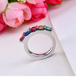 Bague en acier inoxydable poli sertie de cinq pierres carrées colorées sur fond blanc