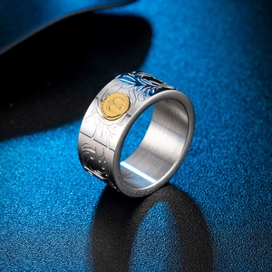 Macro shot of titanium steel ring with scroll engraving and golden sun emblem