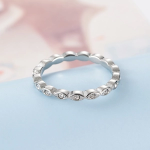 Vista macro de anillo plateado con engastes de forma oliva y circonitas redondas estilo boho