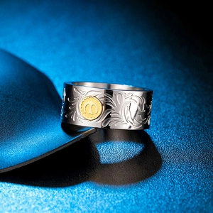 Detail shot of wide vintage band ring featuring gold bird emblem and floral carvings