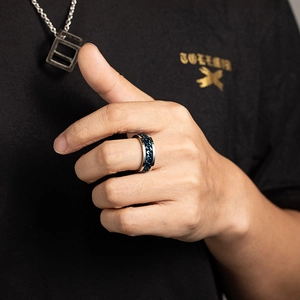 Close-up of titanium steel punk ring with blue chain inlay and polished silver edges