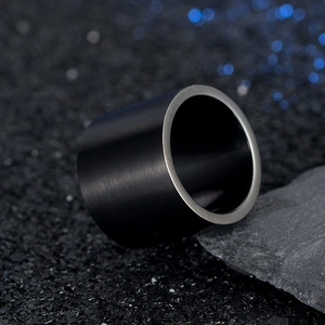Macro detail of men's wide titanium steel ring with black brushed finish and silver edges