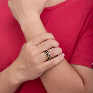 Detailed view of rotating black and gold Freemason ring worn on male finger