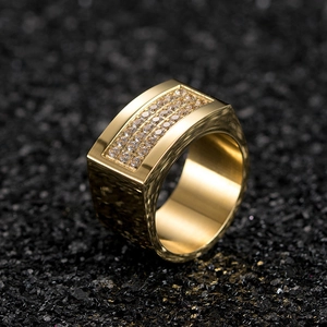 Macro shot of gold plated men's signet ring with triple row square crystal accents