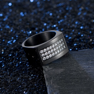Macro shot of black brushed metal ring for men with three rows of sparkling zircon stones