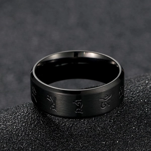 Macro detail of black stainless steel ring with Sanskrit engraving and brushed finish