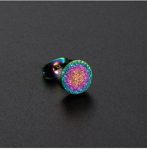 Detalle macro de pendientes de acero de titanio arcoíris con acabado de arena púrpura