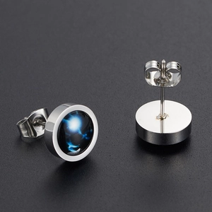 Macro shot of luminous constellation stud earrings with starry nebula pattern in silver frame