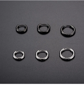 Set of 6 black and silver stainless steel hoop earrings in three sizes on a dark background
