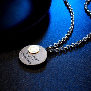 Vista macro del colgante de moneda de plata con smiley dorado y texto grabado hip-hop