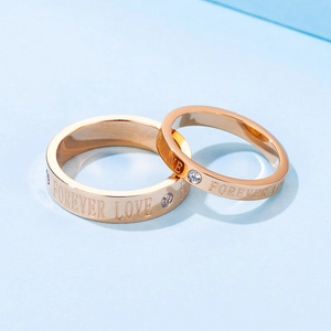 Rose gold titanium steel Forever Love couple rings with sparkling diamonds on blue background