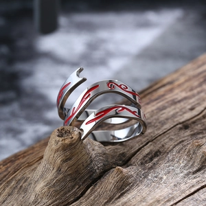 Detail van een zilveren titanium stalen ring met rood vlamemaille op verweerd hout
