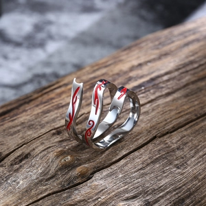 Macro detail van de Nezha-ring met rood emaille op gepolijst zilverkleurig metaal