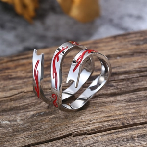 Detail van zilveren Nezha-ring met rode emaille vlampatronen op houten achtergrond