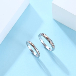 Dettaglio di anelli per coppia in argento con intarsio in oro rosa per San Valentino