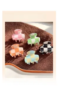 Detailed set of five checkered hair claw clips in vibrant color patterns on a tray