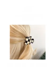 Detail of a small checkered hair claw clip styled on blonde hair for a secure half-up look