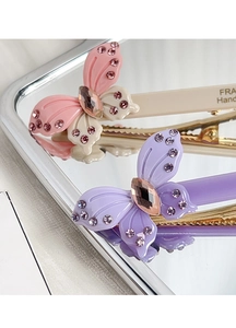 Detailed macro view of butterfly hair clips with sparkling rhinestones and acetate finish