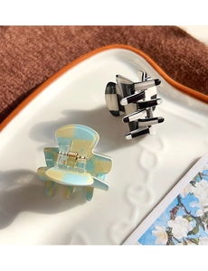 Detail of checkered hair claws in black, white, and blue hues on a decorative tray