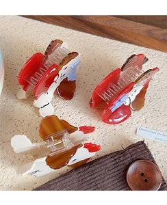 Detail of red cartoon dog hair claw clips made of acetate with spring mechanism