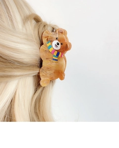 Detail showing the cute bear hair claw clip worn on blonde hair with polished finish