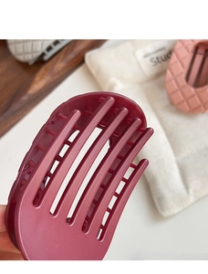 Dettaglio di pinza per capelli opaca bordeaux con denti curvi per capelli folti