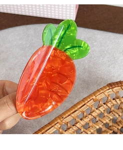 Detail einer kreativen Karotten-Haarklammer aus strukturiertem orangefarbenem Acetat