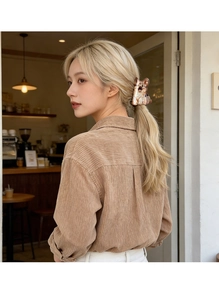 Close-up of a cute Corgi shaped acetate hair claw clip worn on blonde wavy hair