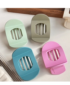 Détail de quatre grandes pinces à cheveux mates aux couleurs macaron et design ovale
