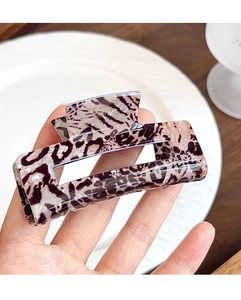 Close-up of leopard pattern rectangular hollow hair claw clip held by hand
