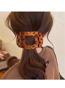 Détail d'une pince à cheveux motif écaille de tortue portée en queue de cheval basse