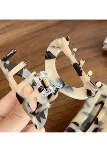 Detail of leopard print acetate hair claw with strong gold metal spring mechanism