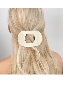 Gros plan d'une grande pince à cheveux géométrique crème mate sur les cheveux