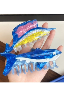 Detail of acetate tuna and shark hair claws with blue marble pattern held by hand