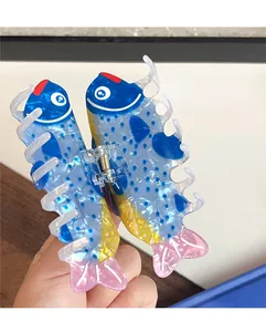 Detailed view of tuna-shaped hair claw clip in vibrant blue with a strong metal spring