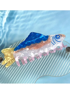 Detail view of the ocean tuna fish hair claw clip made of blue and yellow acetate material